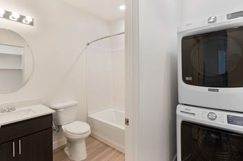 A white toilet sits next to a white bathtub in a small bathroom.